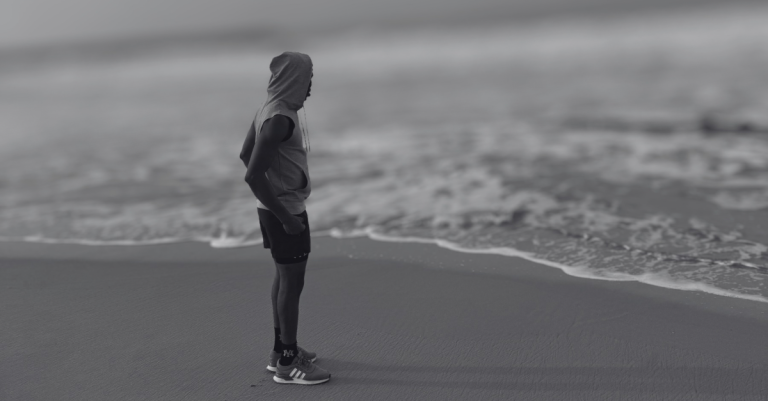 Anthony standing at the beach side looking out at the sea during a calm recovery moment, reflecting on Recovery Mistakes After 30.