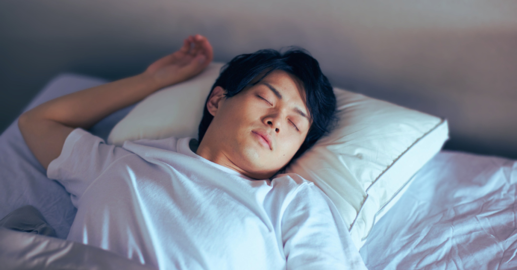 Asian man sleeping on his back facing the ceiling in bed, representing common Sleep Mistakes After 30 that can affect recovery, energy, and overall health.