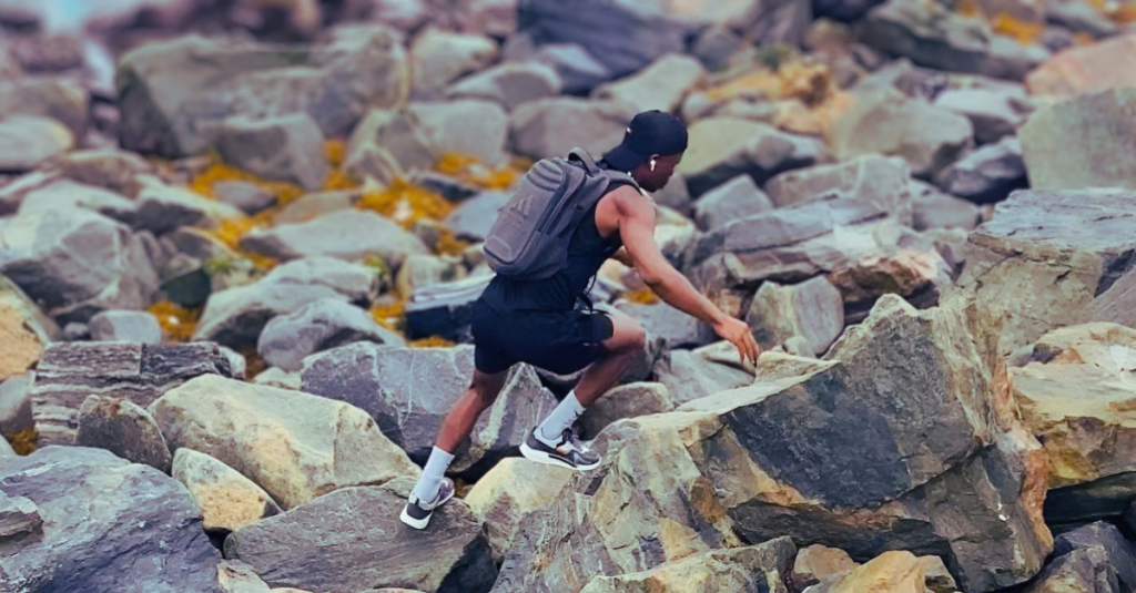 Anthony is running on the rock in a medium shot during an outdoor workout. Keyword: How to build a fitness mindset after 30