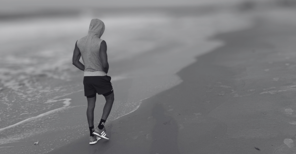 Anthony walking along the beach side, enjoying a calm recovery walk while reflecting on Recovery Mistakes After 30.