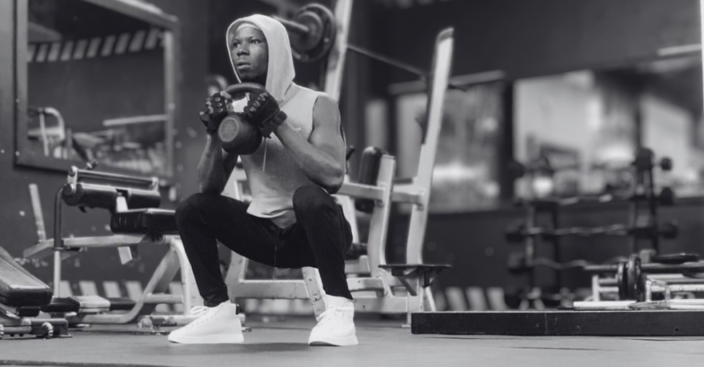 Strength Training Recovery Tips After 30: Anthony performing a kettlebell squat during a lower-body workout.