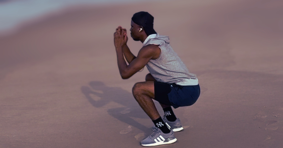 Anthony performing a bodyweight squat as part of home workouts for weight loss after 30, focusing on proper form, lower-body strength, and calorie burning.