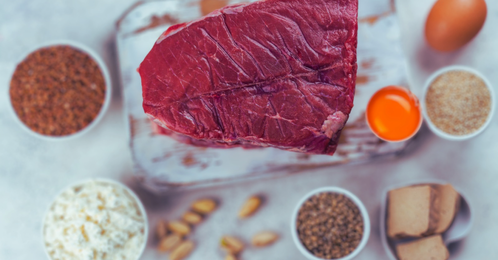 Protein After 30 high-protein foods including lean beef, beans, eggs, chickpeas, and tofu arranged on a table to support muscle growth and fat loss.
