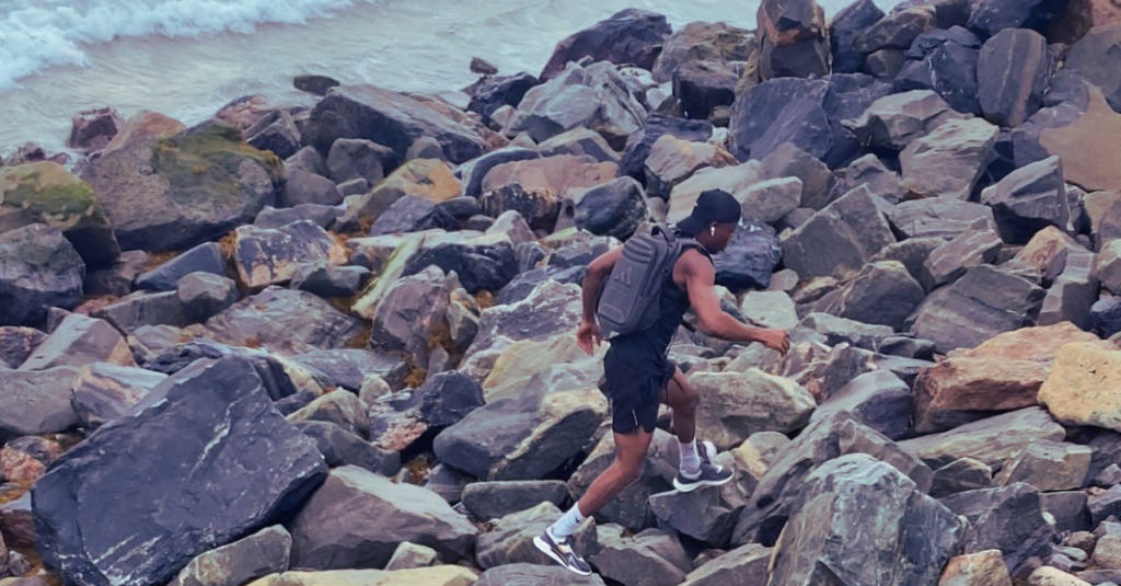 Anthony running on rocky terrain in a side shot during an outdoor workout. Keyword: How to build a fitness mindset after 30