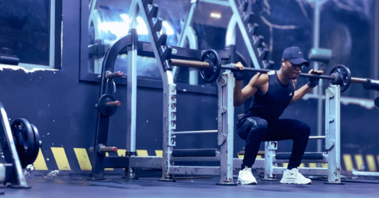 Anthony performing a barbell squat in the gym as part of Strength Training for Weight Loss After 30, focusing on lower-body strength and fat loss.