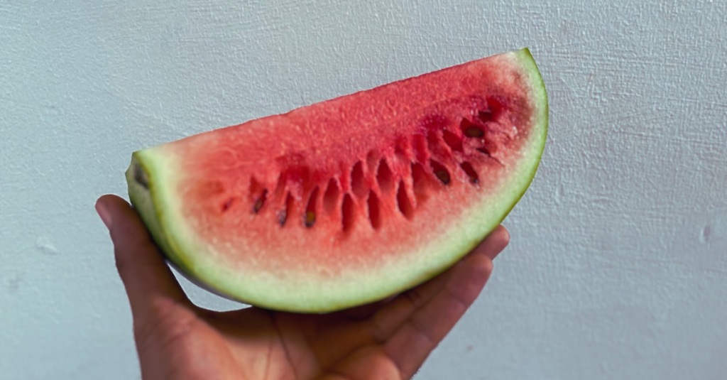 Anthony holding a slice of watermelon as part of the best foods for weight loss after 30.