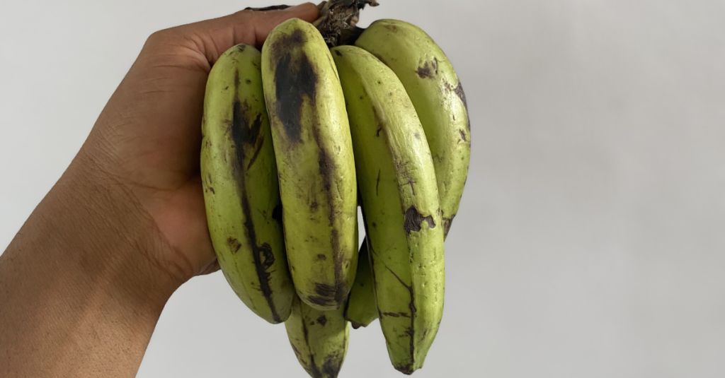Anthony holding a bunch of bananas, highlighting high-calorie foods that can provide energy, carbohydrates, and nutrients for healthy weight gain.