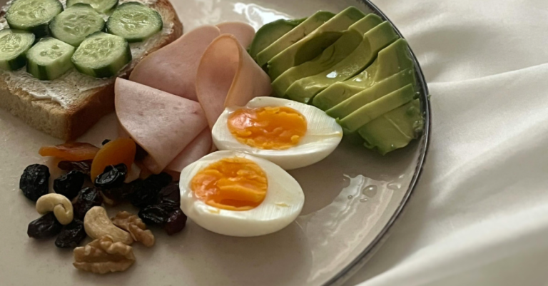 Bowl of boiled eggs, diced eggs, cucumber, and nuts prepared as part of high-protein breakfasts for a healthy and balanced morning meal.