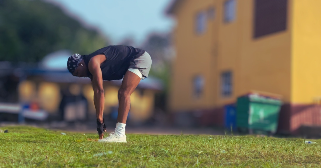 Anthony performing a toe-touch stretch during how to plan weekly home workouts after 30, improving flexibility and preparing the body for exercise.