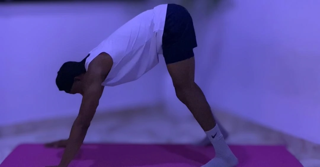 Home Workout Mistakes: Anthony preparing for a home workout session by warming up before exercise.