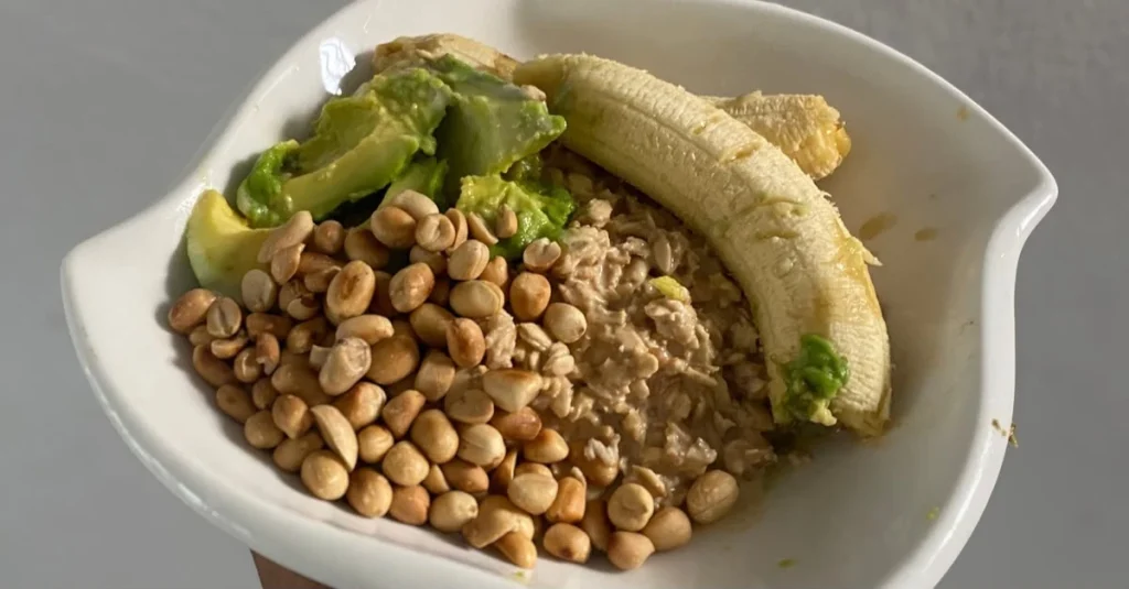 Bowl of overnight oats topped with banana slices and nuts served with avocado