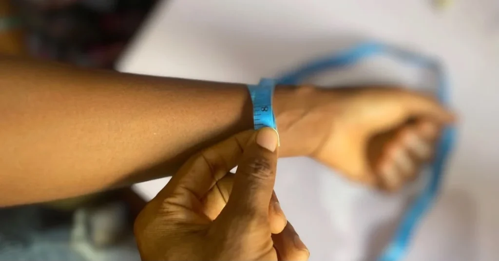 Anthony measuring a woman’s wrist with a tape to learn how to track weight loss