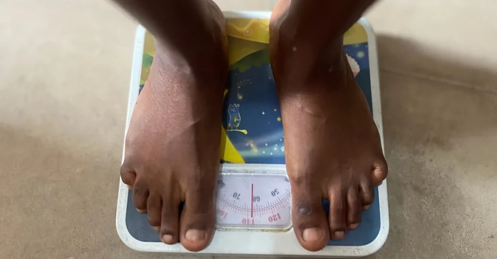 Woman standing on a scale to learn how to track weight loss