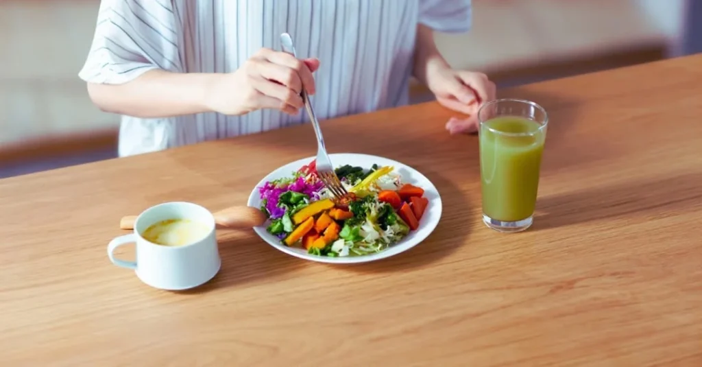 Woman enjoying a healthy meal with a smoothie and tea as part of healthy eating habits after 30.