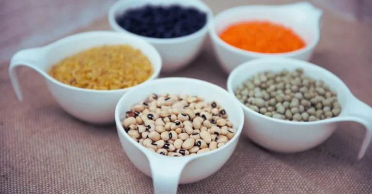 High-protein foods including a bowl of beans and a bowl of lentils for muscle building and healthy eating after 30