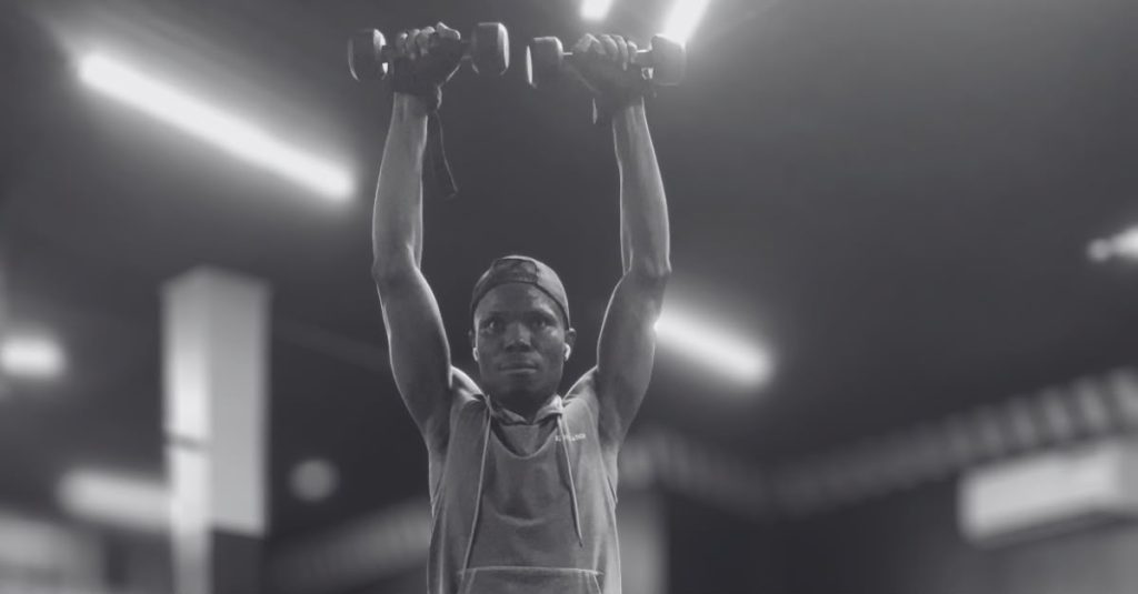 Anthony performing Arnold press with dumbbells to target the shoulder muscles and improve upper-body strength