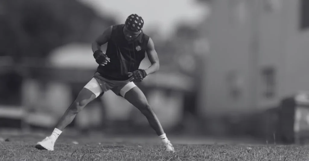 Anthony prepares to perform side lunges with proper stance before starting the movement.