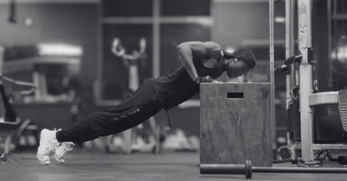 Anthony performing incline push-ups to demonstrate what muscles do push-ups work, including the chest, shoulders, triceps, and core.