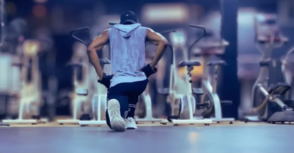 Back view of Anthony performing bodyweight walking lunges with proper form during a lower-body workout