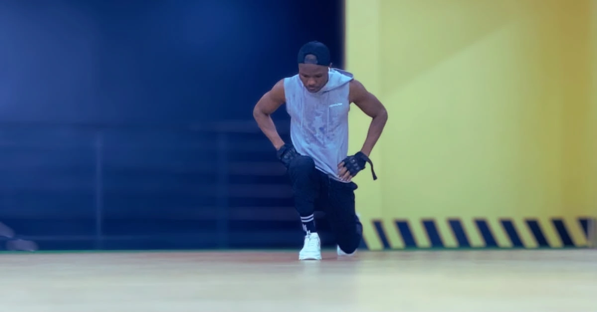 Anthony performing bodyweight walking lunges with proper form during a lower-body strength workout