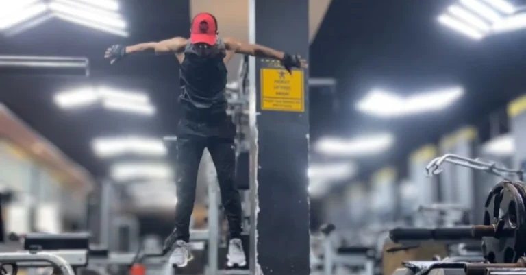 Anthony performing a burpee exercise in mid-air during a full-body workout.