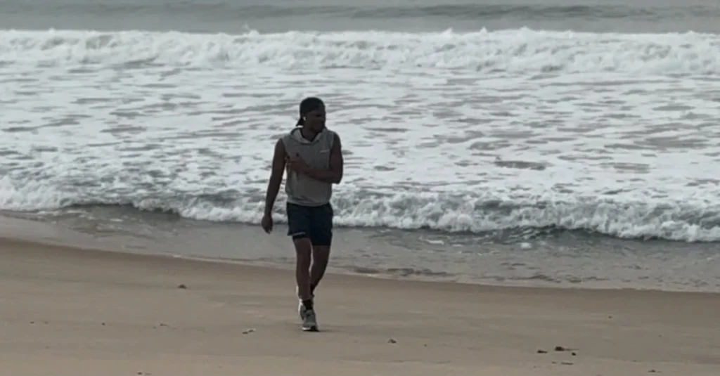 Anthony walking along the beach