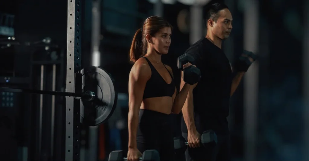 Woman doing dumbbell curls with her trainer