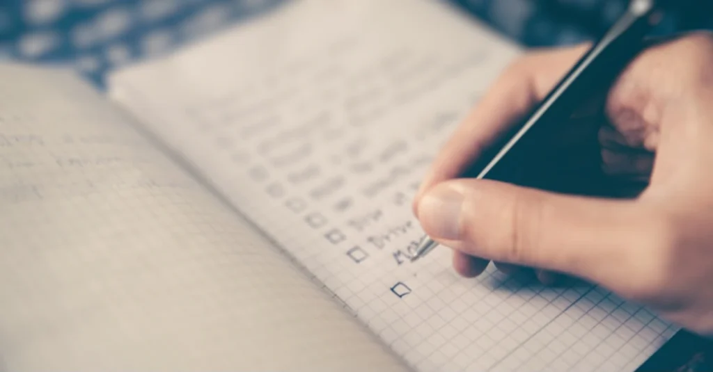 Person writing down fitness goals in a notebook