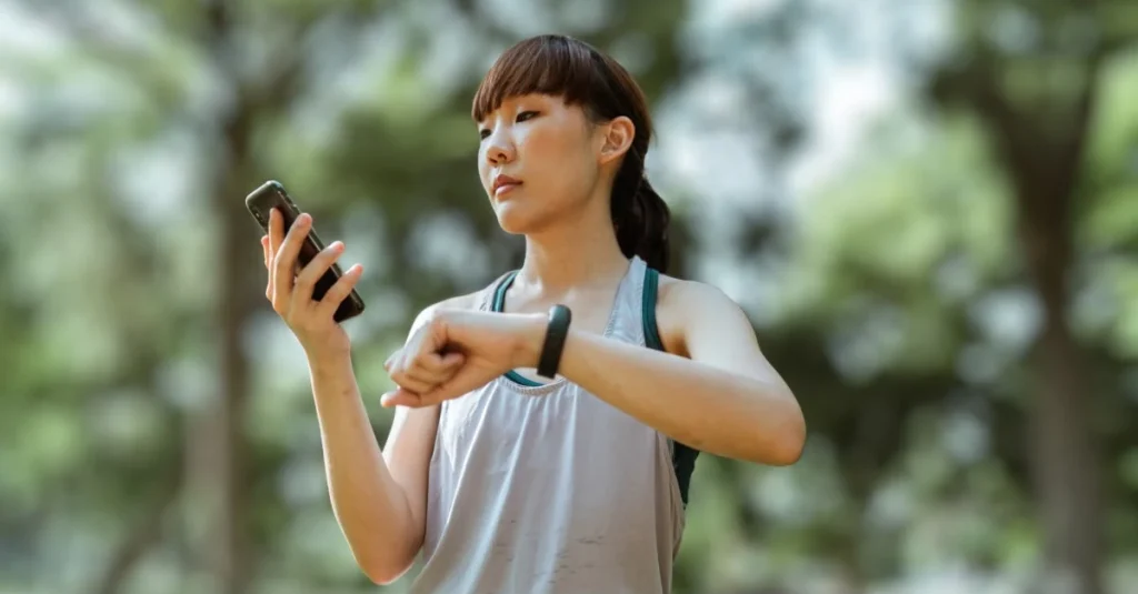 Lady connecting her phone to a smartwatch to track fitness progress