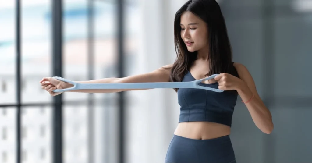 A woman holding a resistance band for strength training at home.