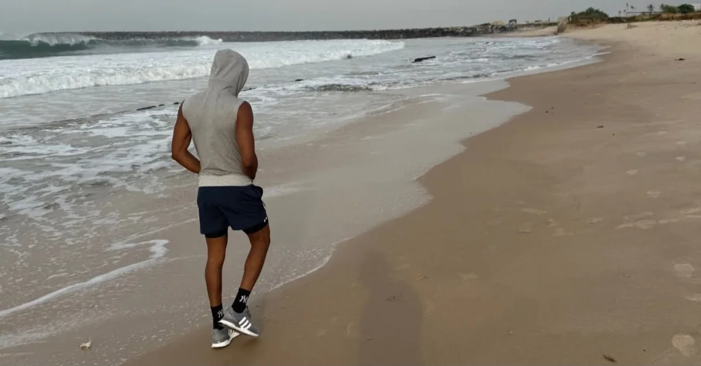 Can You Lose Weight by Walking? Back view of Anthony walking along the beach during a brisk walk for healthy weight loss after 30.