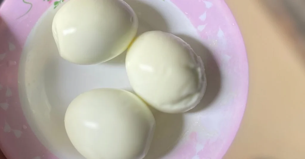 Anthony holding a bowl with three peeled eggs while discussing how much protein is in an egg