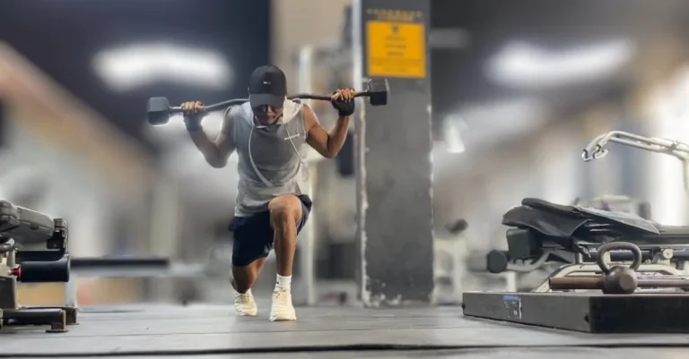 Anthony doing lunges with an EZ bar during strength training recovery tips