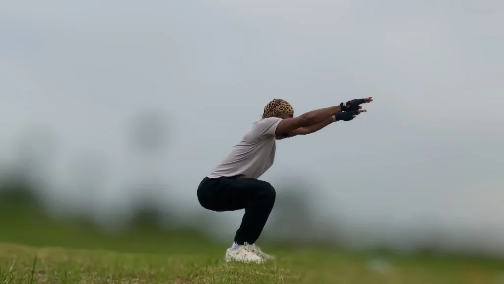 Anthony, founder of Dskulboi Fitness, performing squat exercises to build lower-body strength.